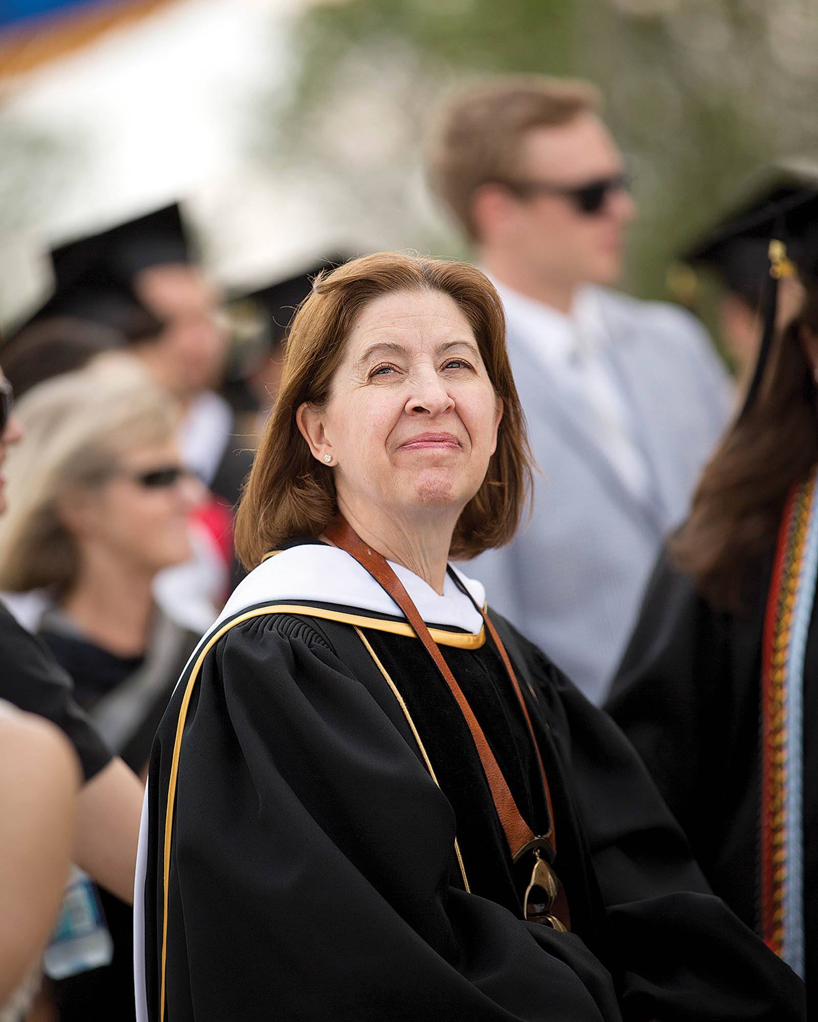 A woman college president looks to the sky with optimism.