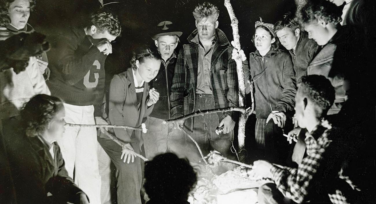 A group of college students around a campfire in 1930s