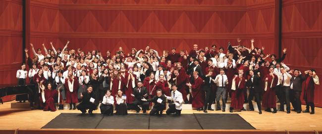 A large group of choir students from the U.S. and Japan mug for the camera. 
