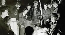 A group of college students around a campfire in 1930s