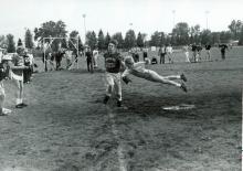 A leap to tag misses in a game of men's intramural softball