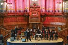 A large jazz ensemble plays in a beautiful concert hall. 