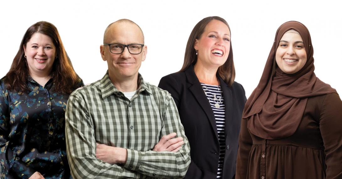 Four faculty members stand together smiling. 